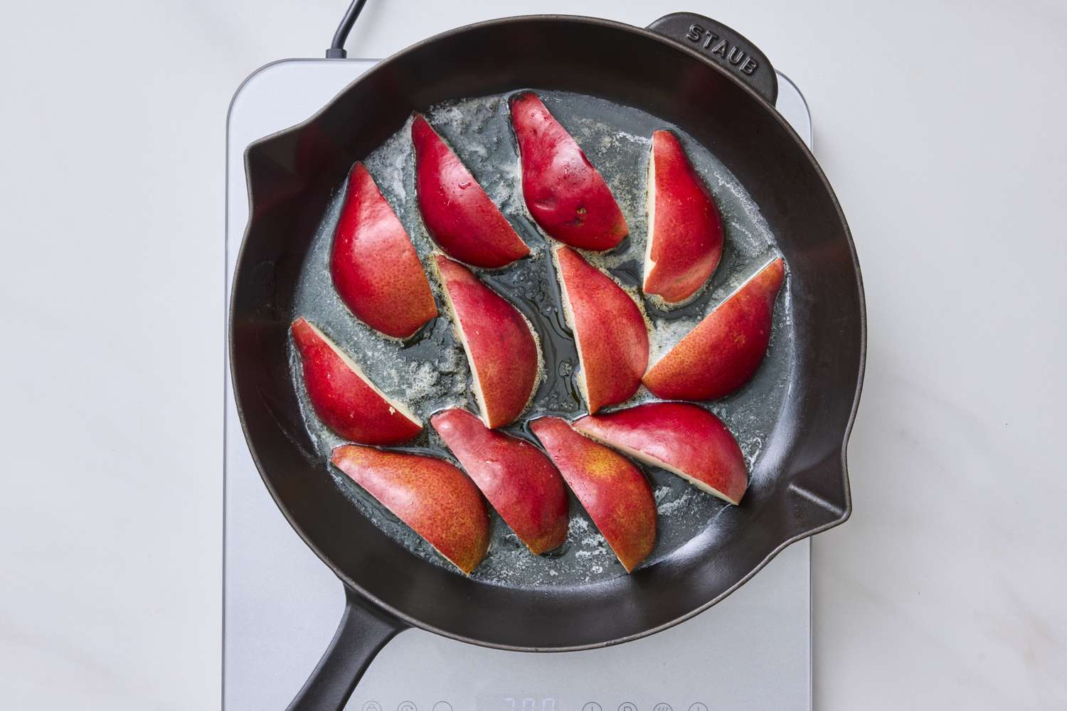 Slices of pears being caramelized in a skillet