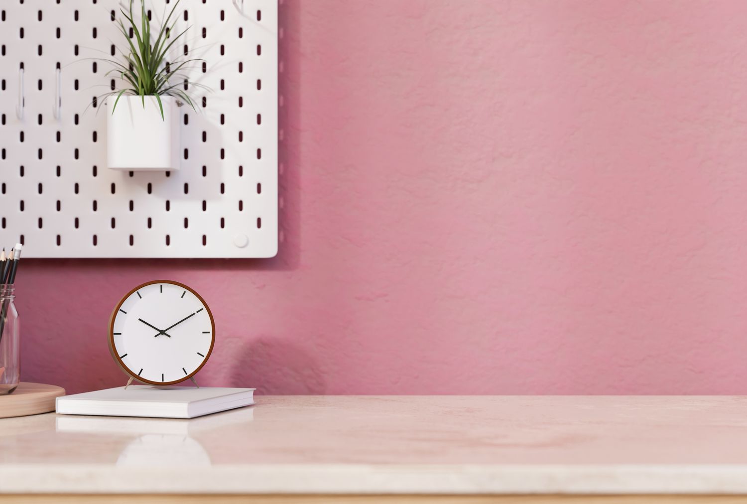 A minimalist desk setup with a clock books and a wallmounted planter on a pink background