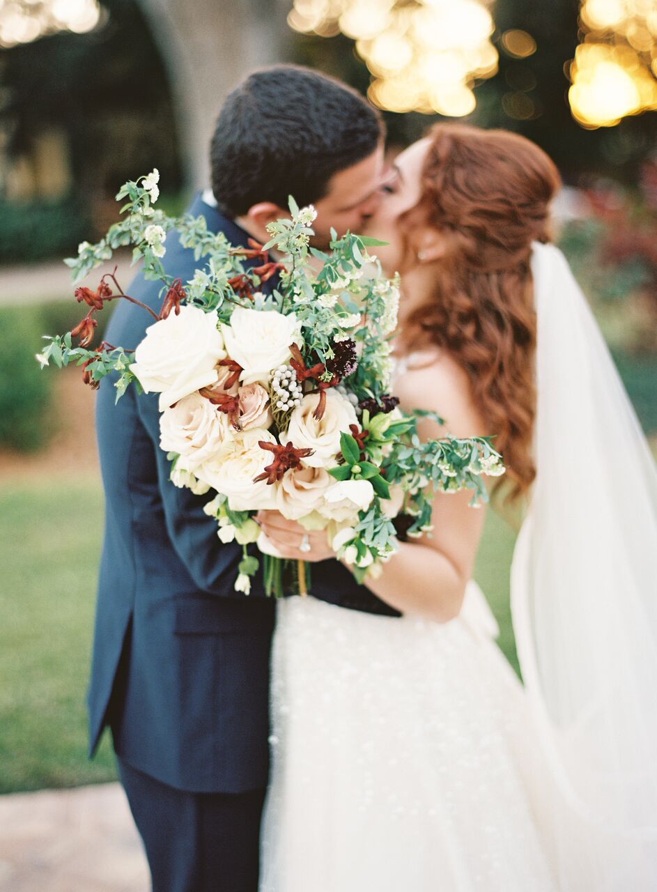 couple kissing with bouquet