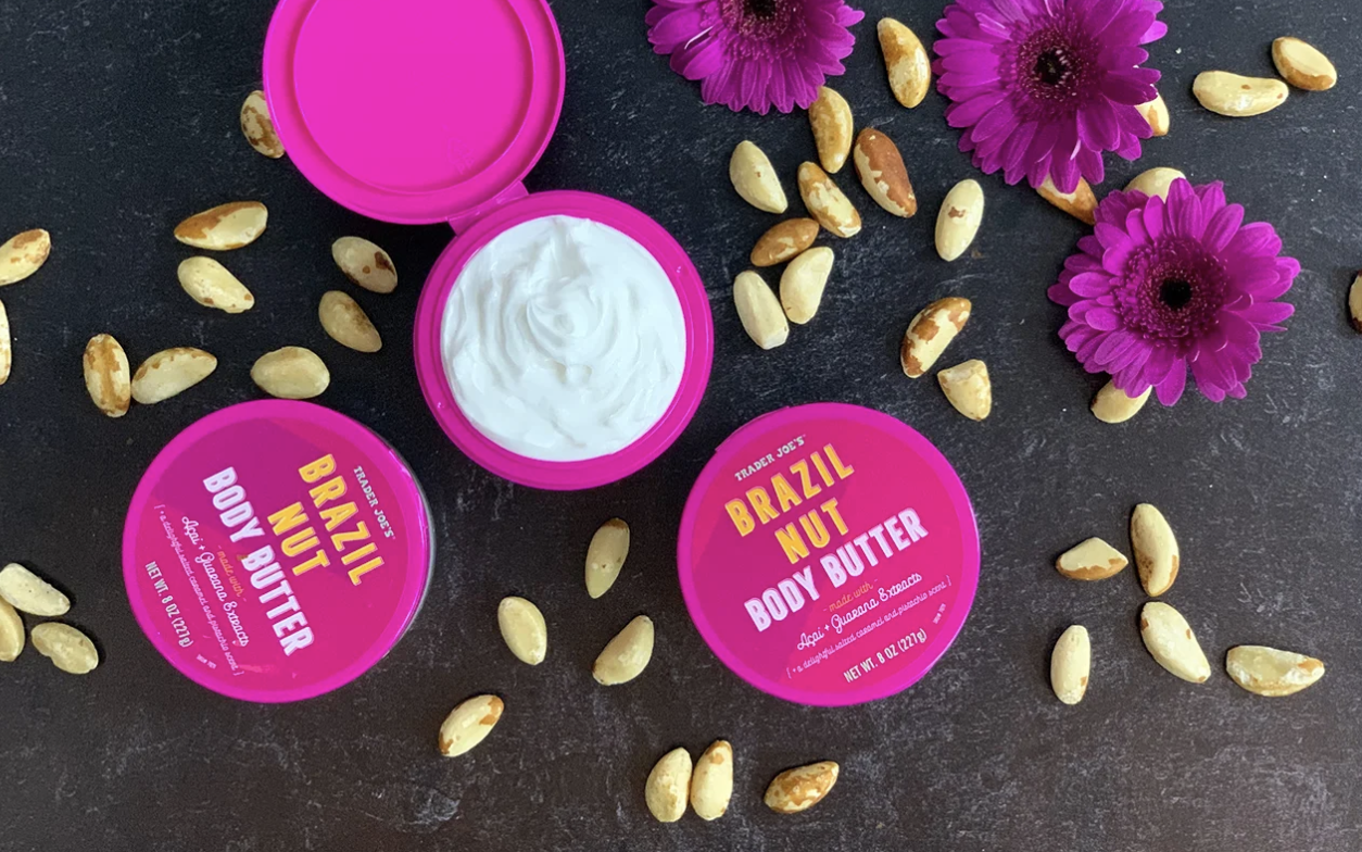 Trader Joes Brazil Nut Body Butter containers with flowers and scattered nuts