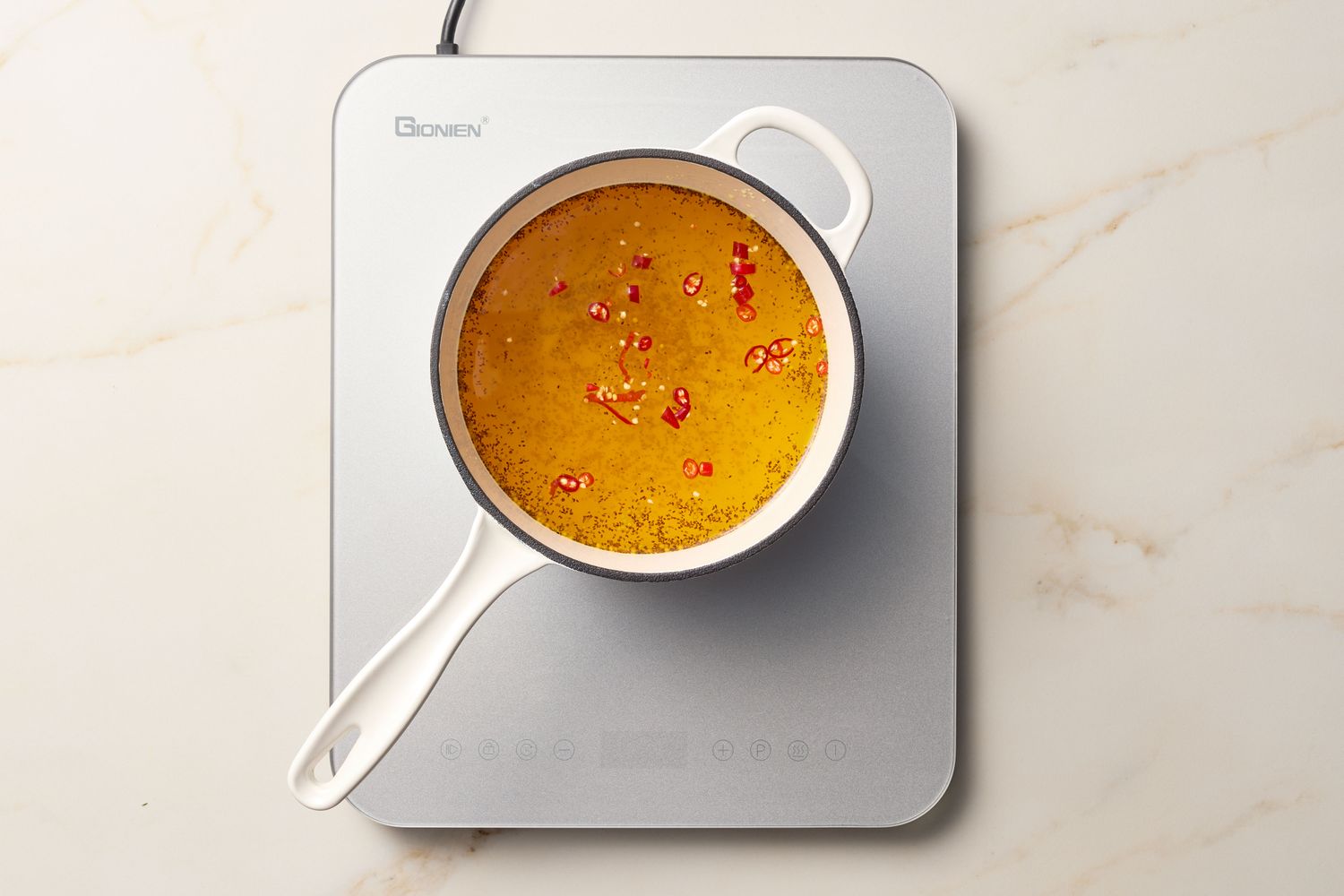 A saucepan with pickling liquid heating on an induction cooktop