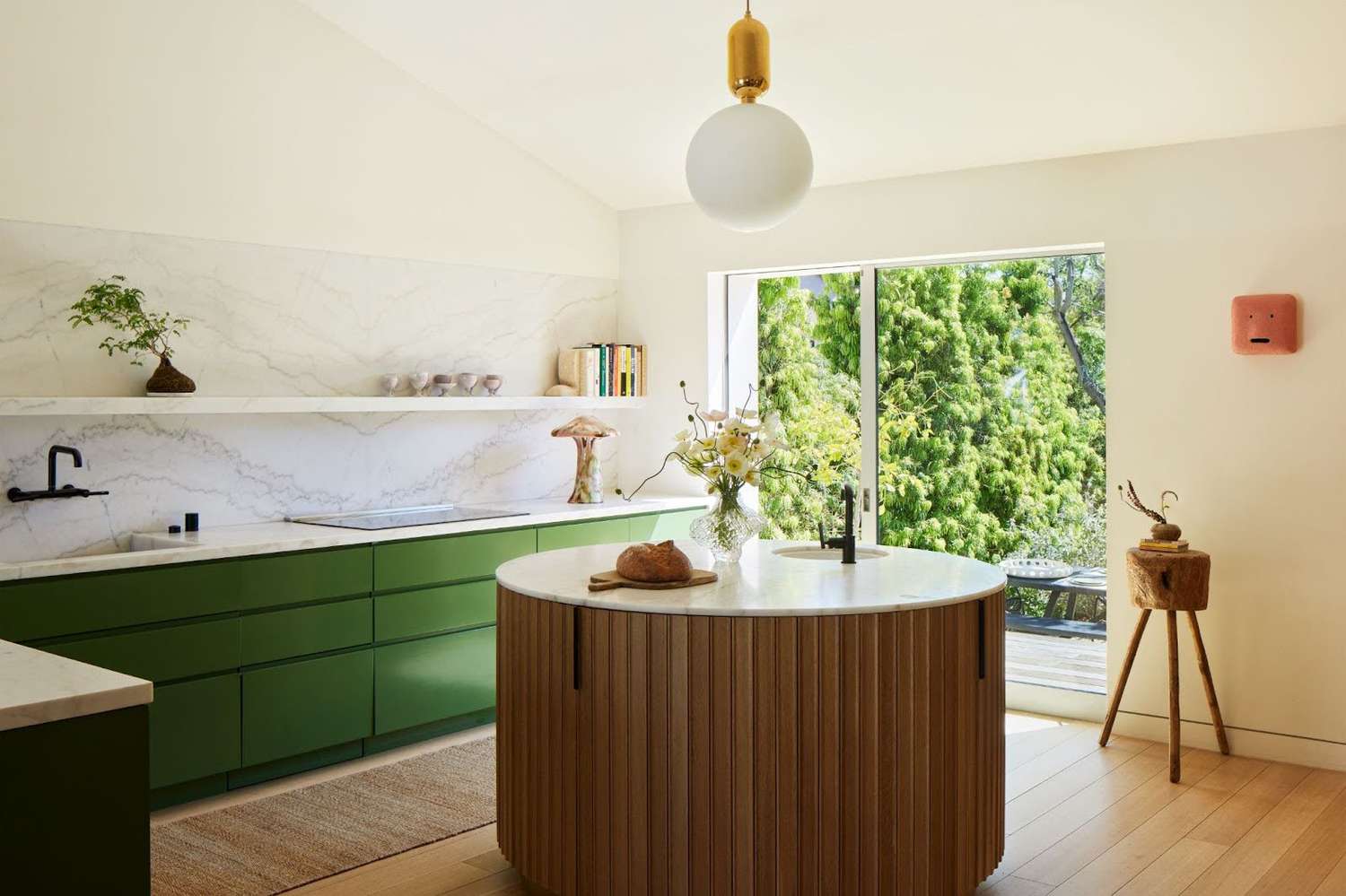 a kitchen with green cabinets and a sphere pendant