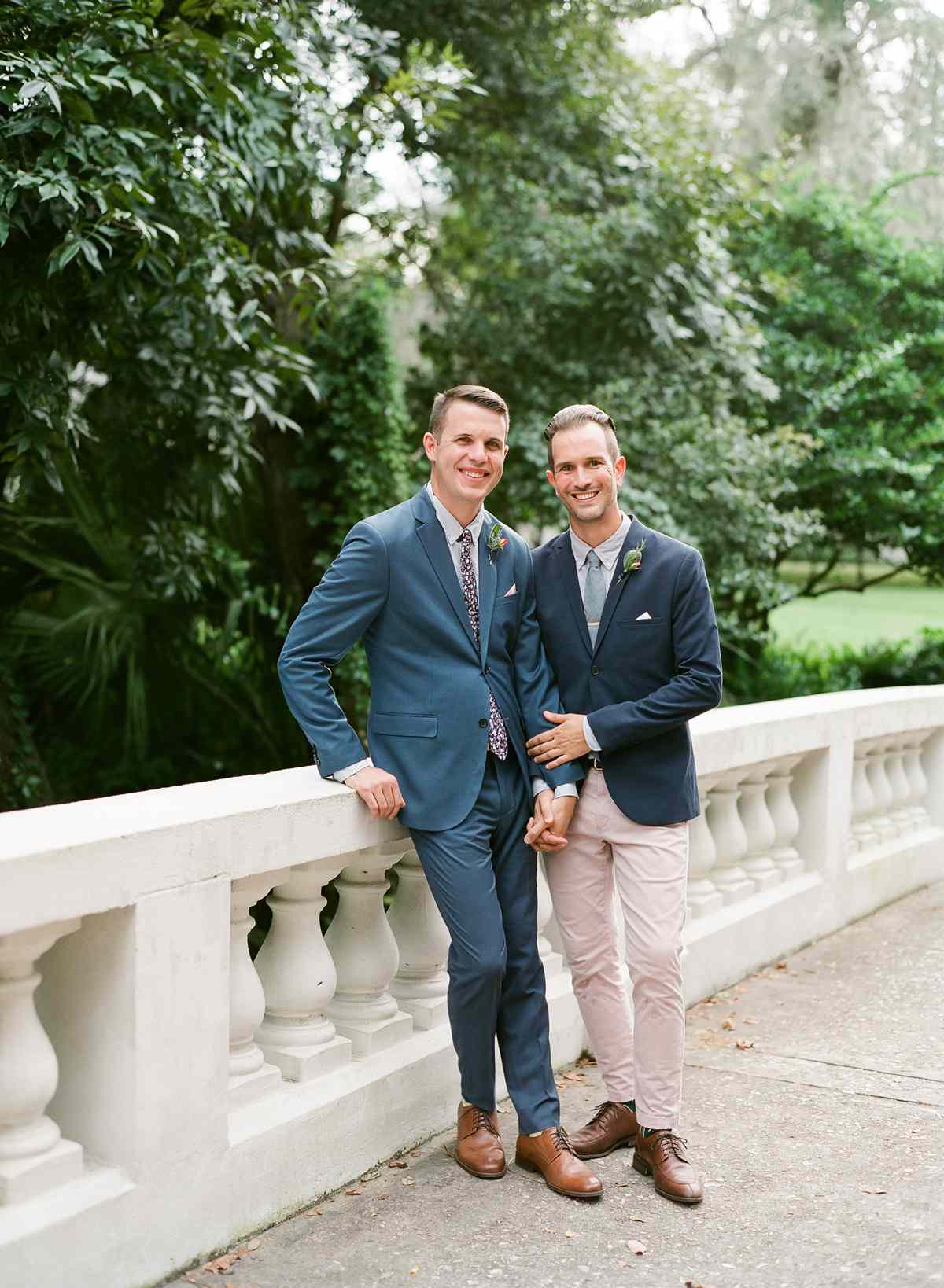 couple grooms pose holding hands