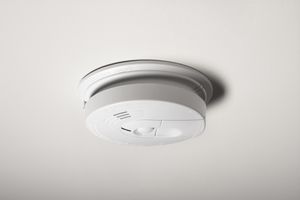 A smoke detector on the ceiling of a home.