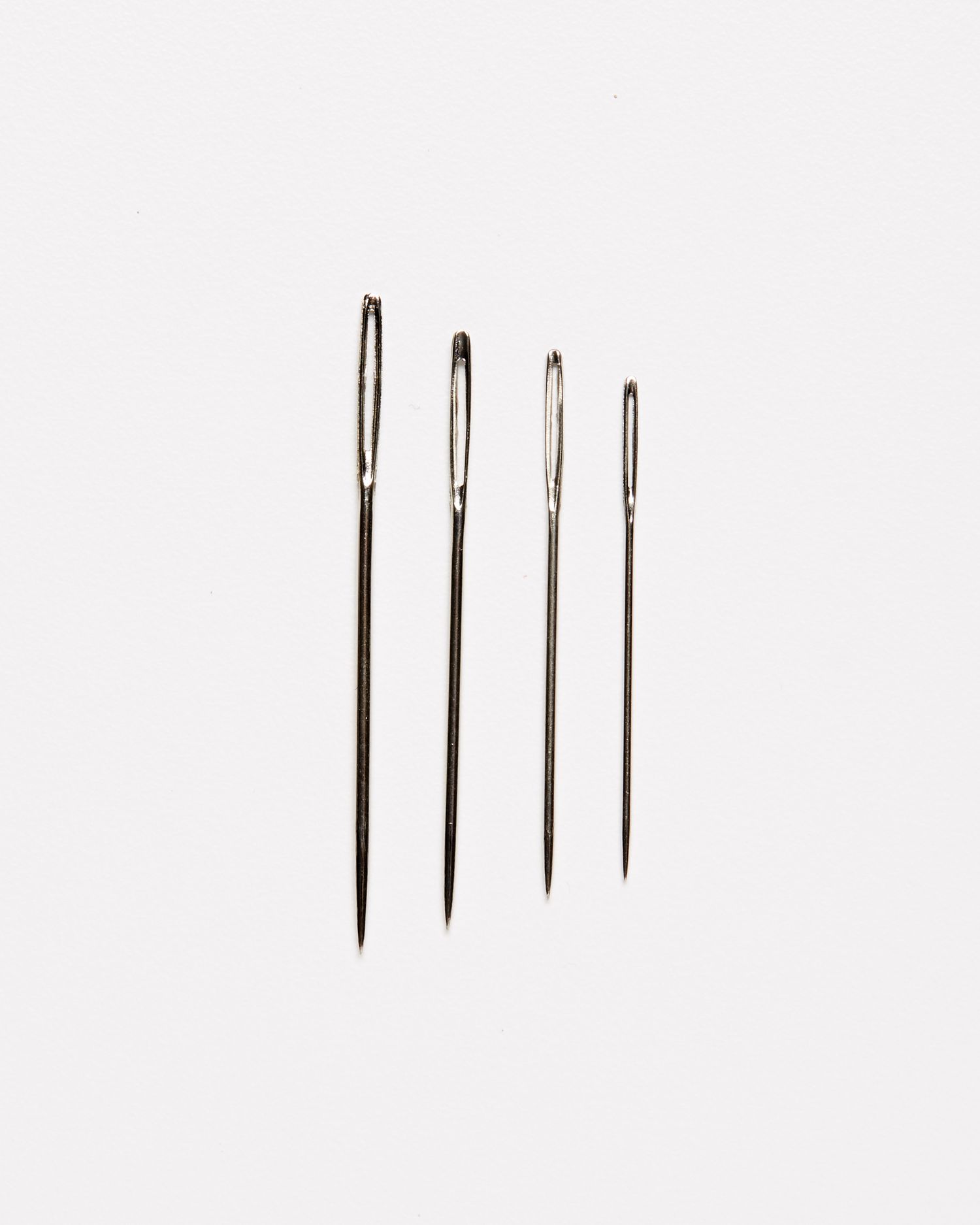 four embroidery chenille needles against a white background