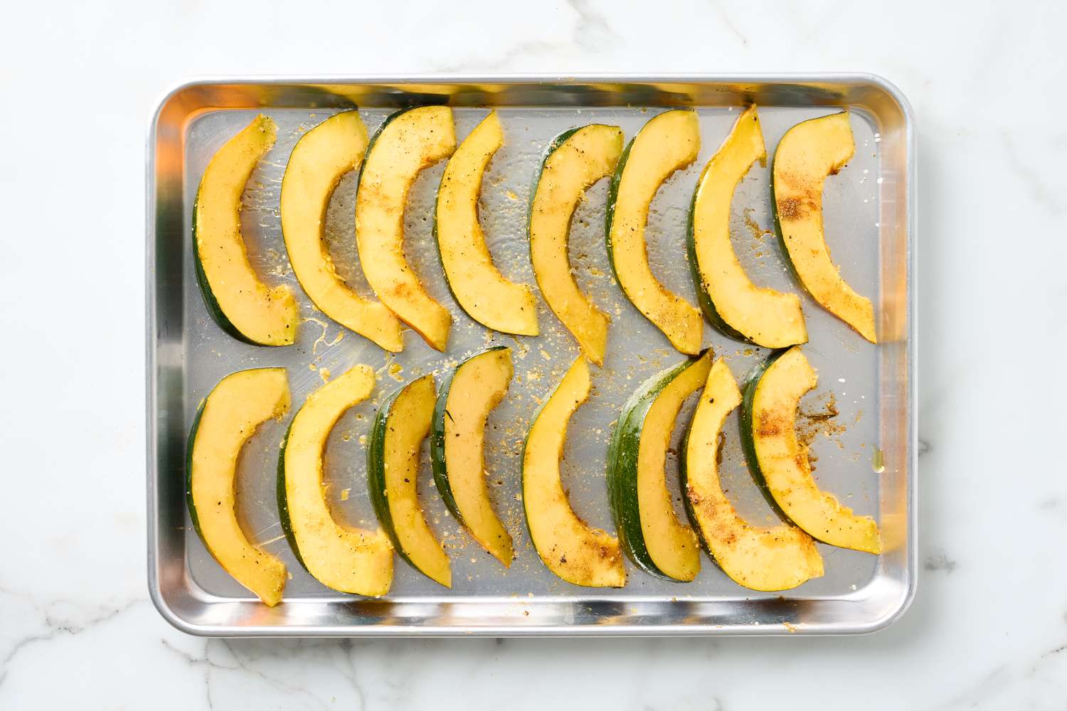 Roasted acorn squash slices arranged on a baking tray