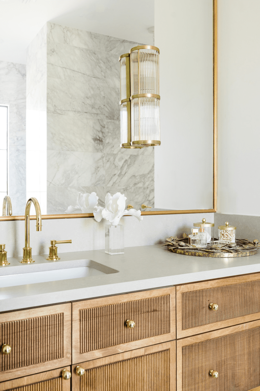 a white bathroom with brass accents