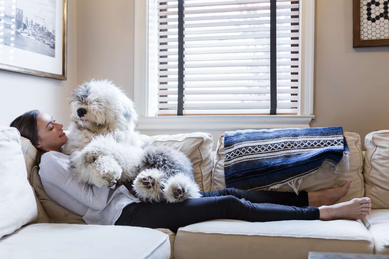 woman on couch with old english sheep dog