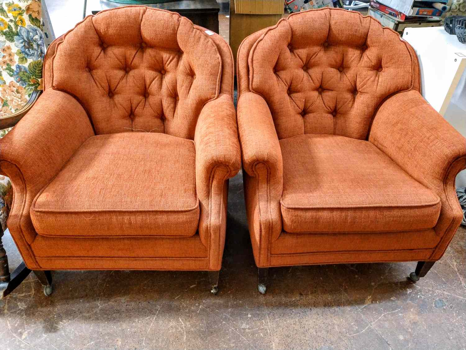 Two tufted armchairs with cushioned seats on a wooden floor