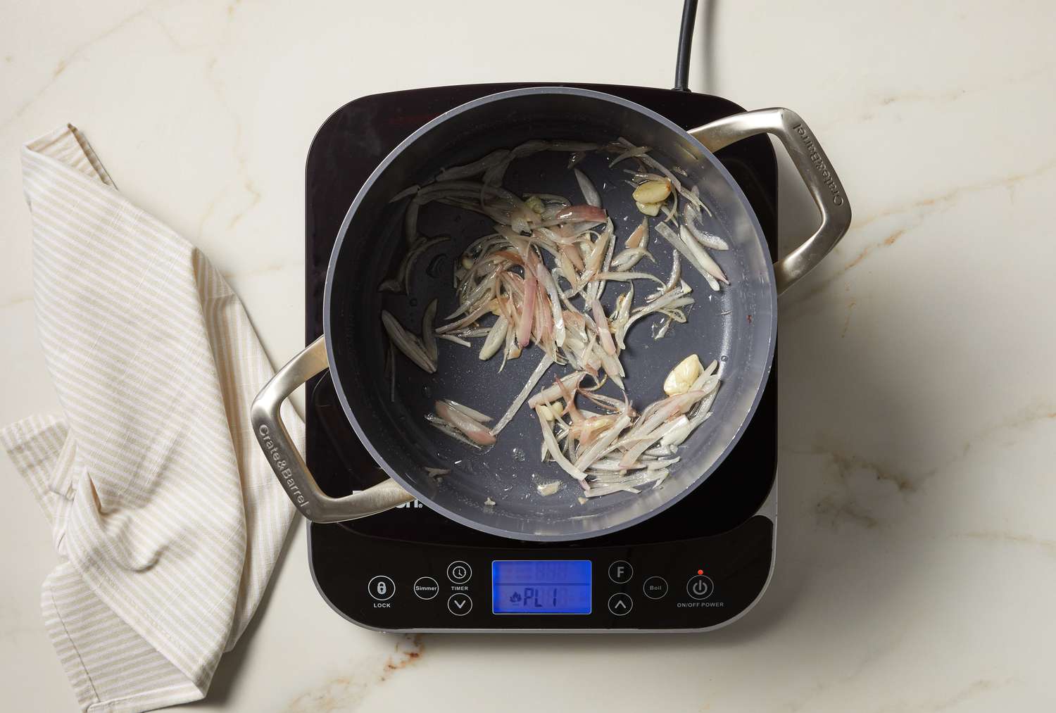 overhead view of vegetables cooking in a pot on marble surface