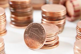 Stacks of US pennies arranged on a white surface