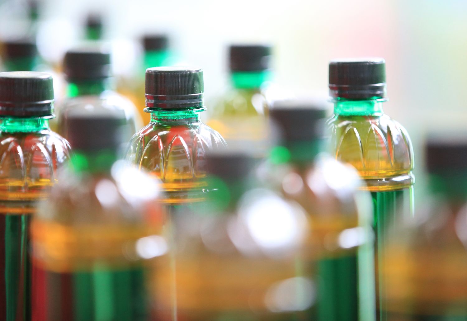Array of bottled beverages with various liquid levels and caps