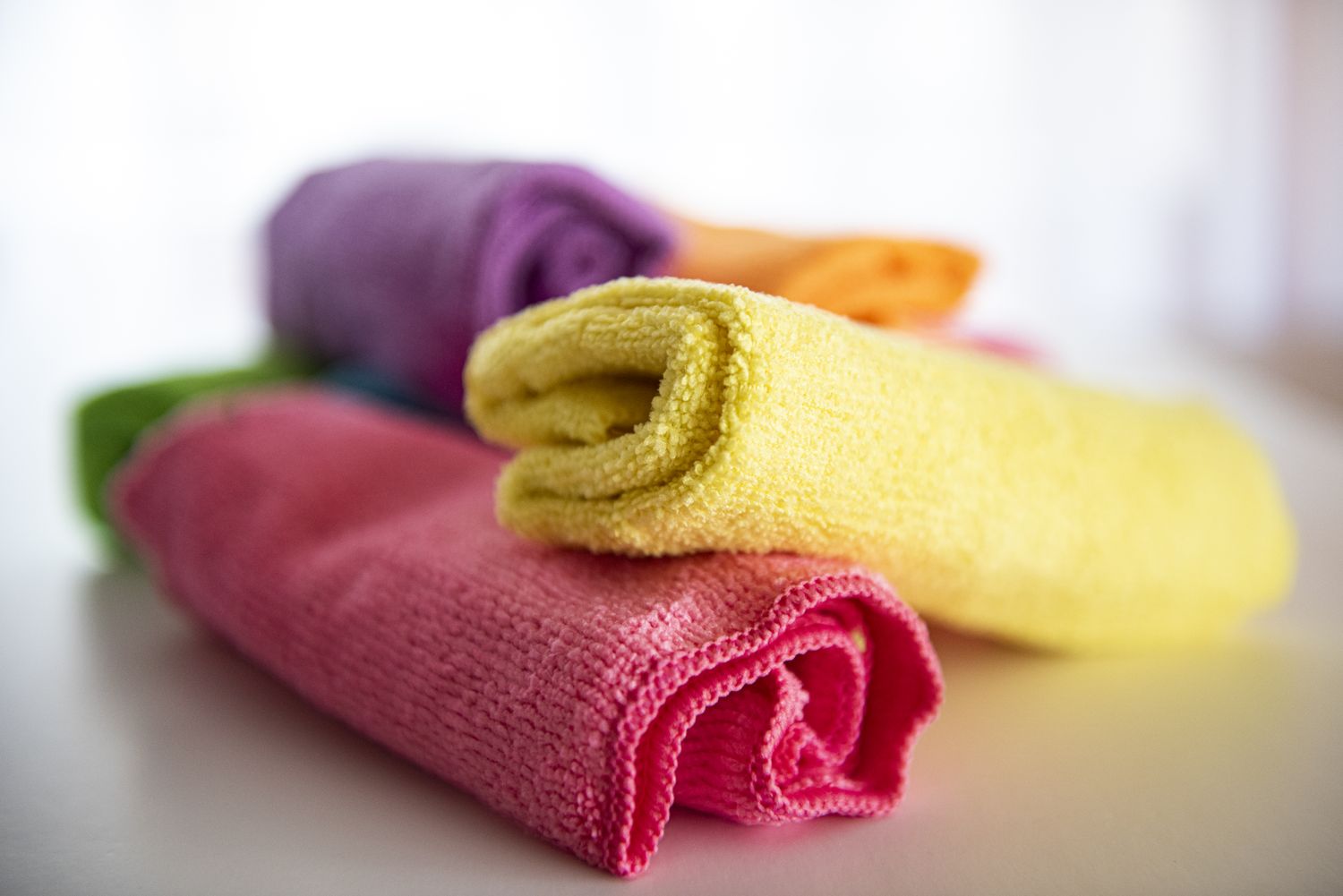 Rolled microfiber cloths stacked in various colors