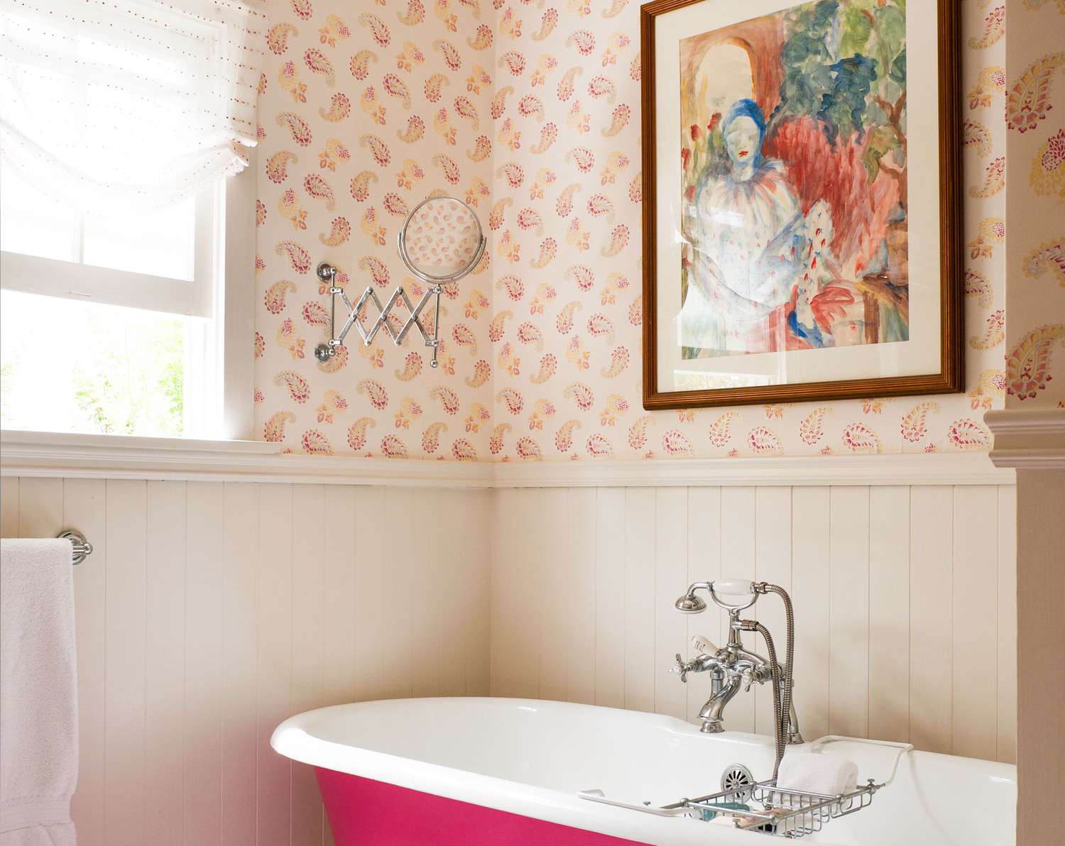 Bathroom with pink wallpaper and bathtub