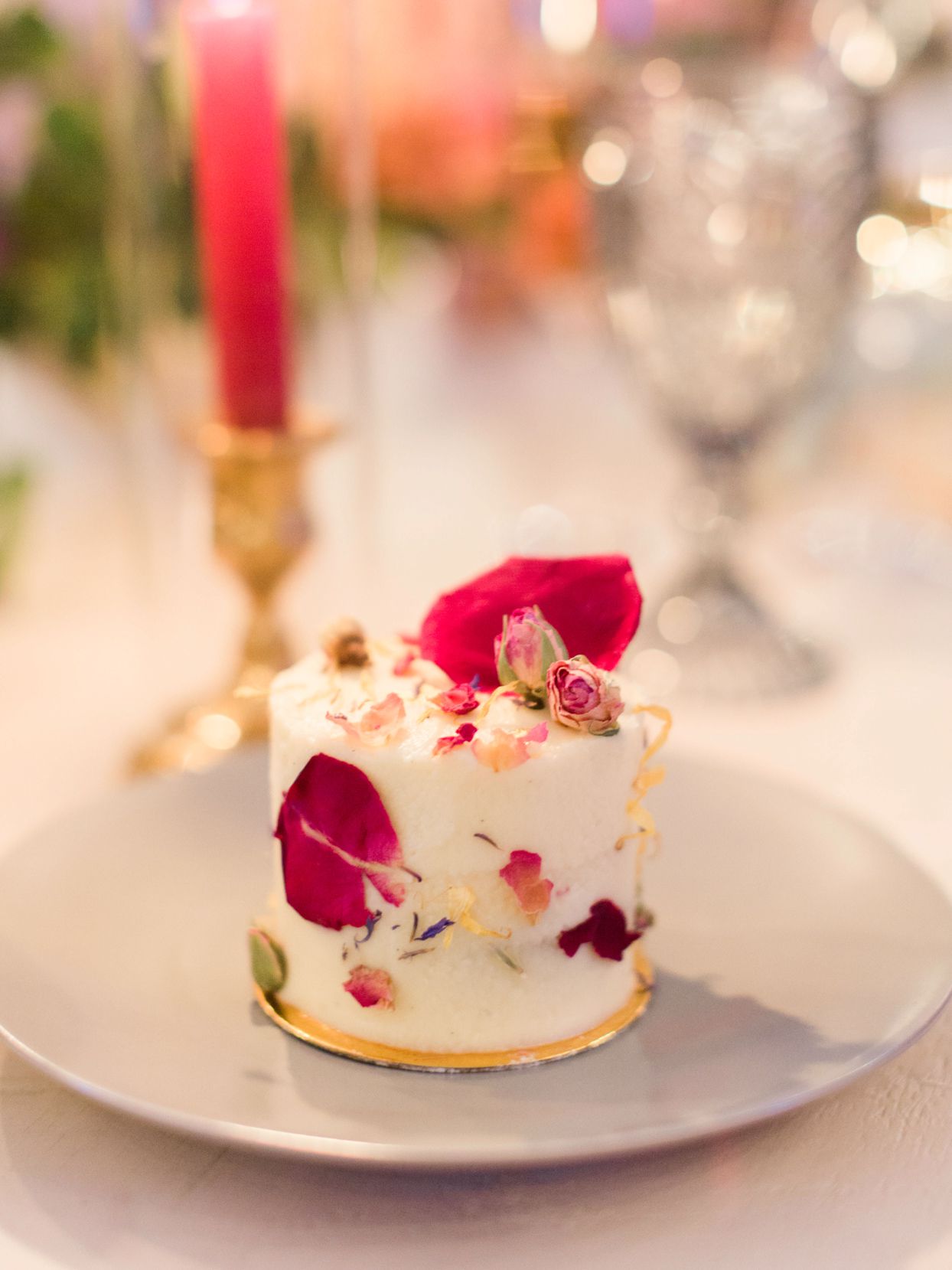 single layer wedding cake with pink flower petals