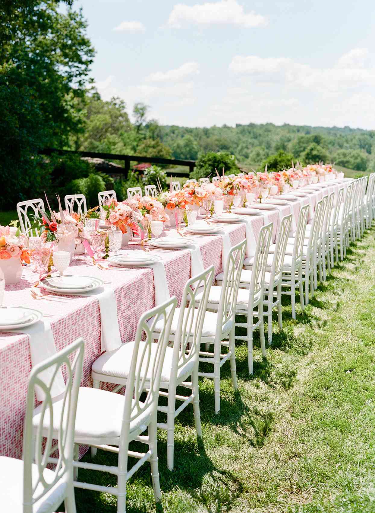 long wedding table with pink runner and flowers