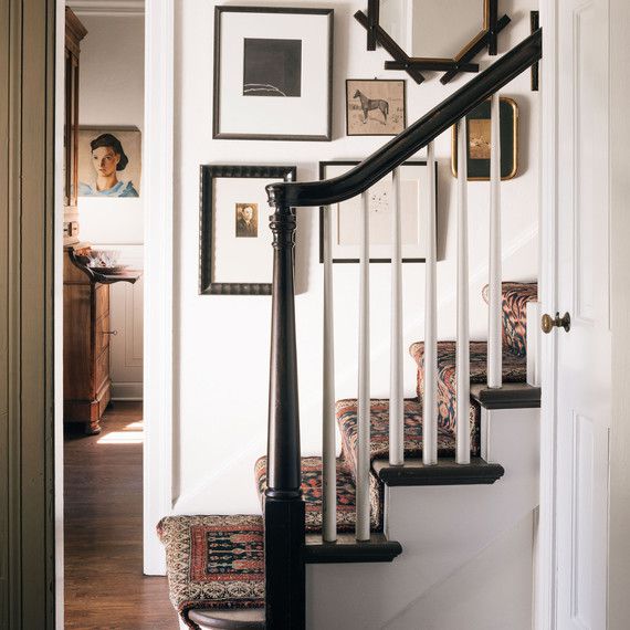 staircase with stair runner and vintage art