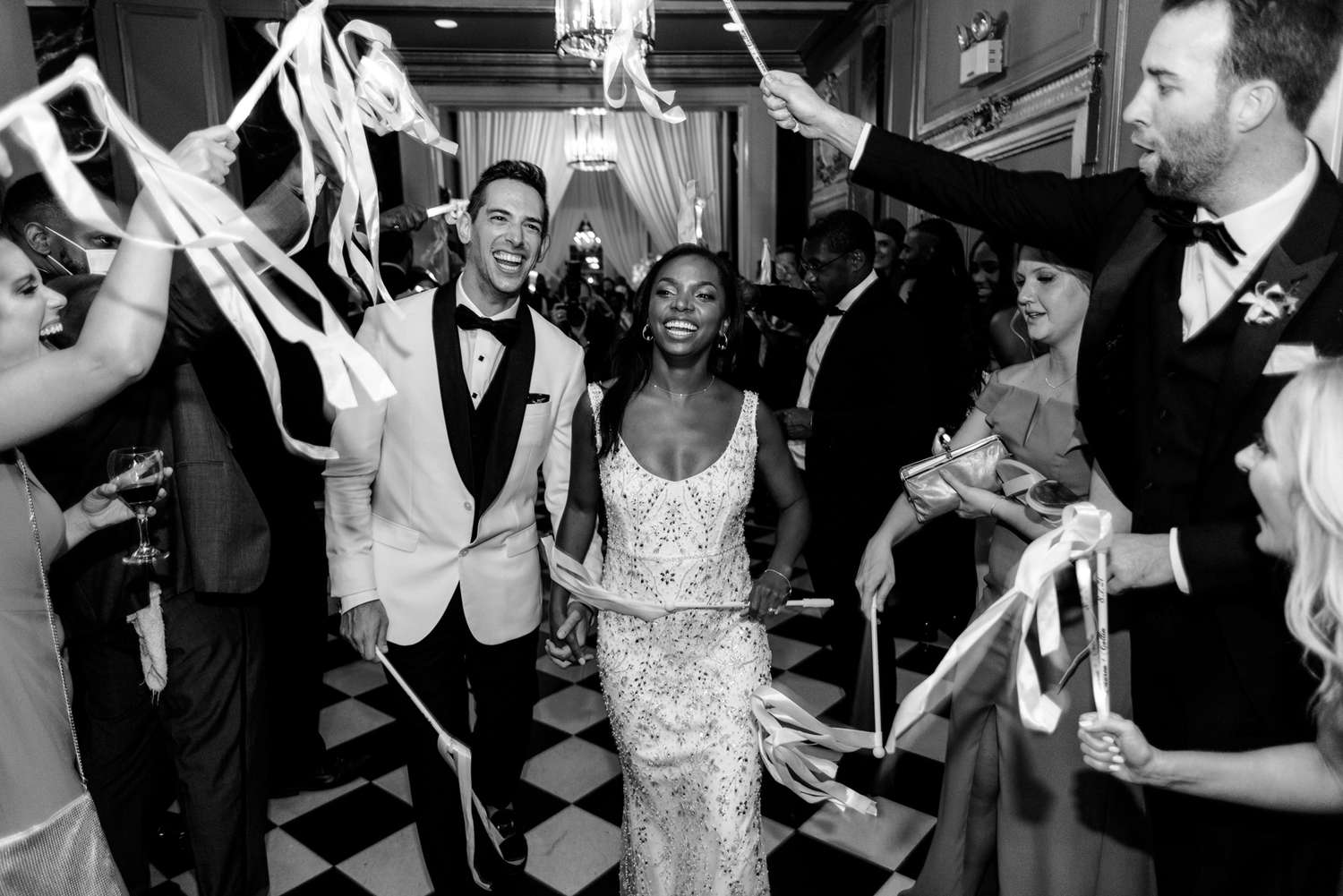 couple exiting while guests hold ribbons