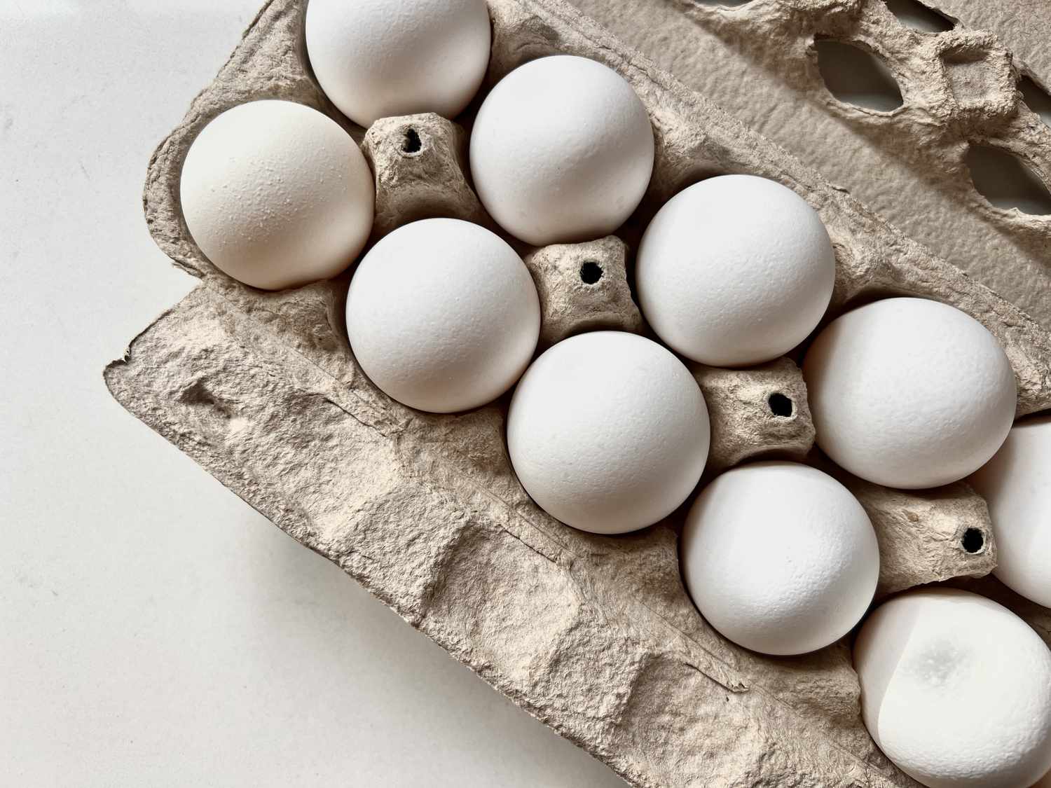 white eggs in grey cardboard carton