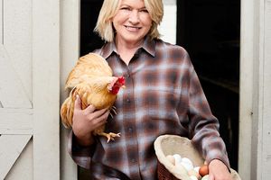 martha holding chicken outside coup