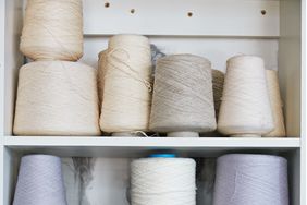 assorted spools of thread on white shelves