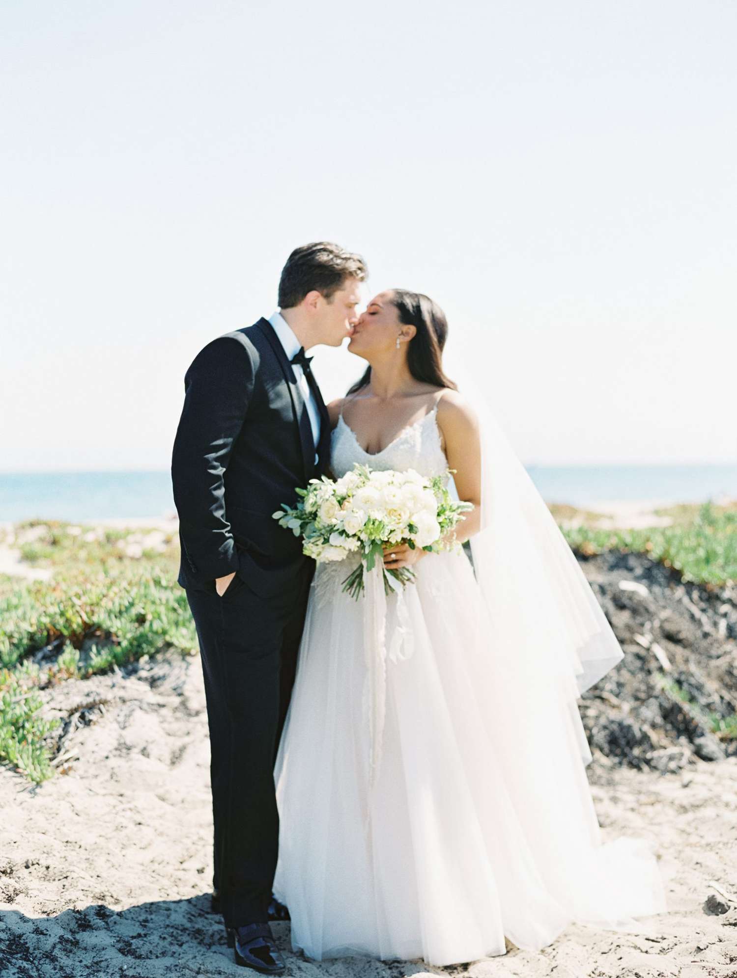 beach wedding dresses couple kissing on sandy walkway