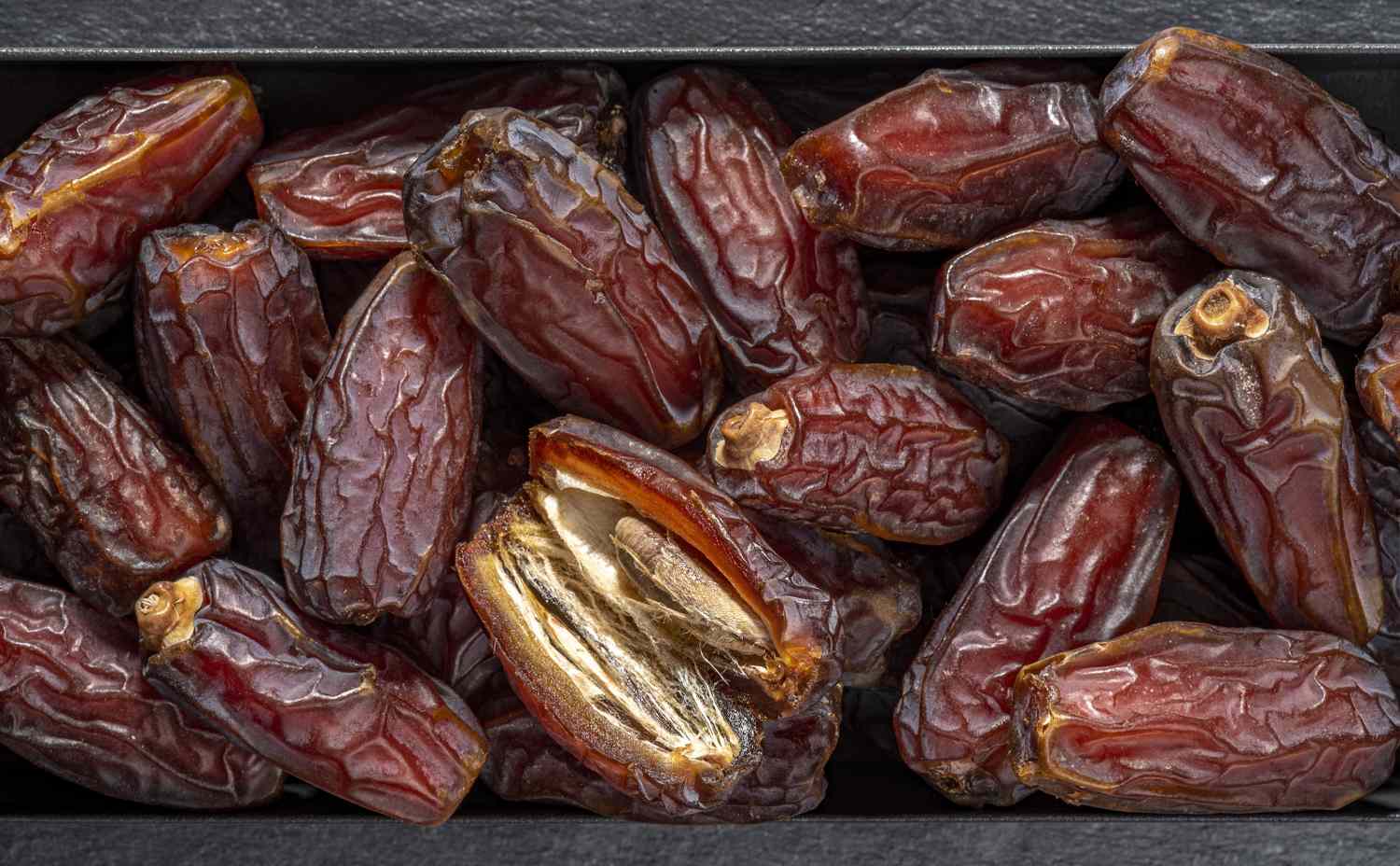 Pile of dates and seeds of date palm fruit close-up