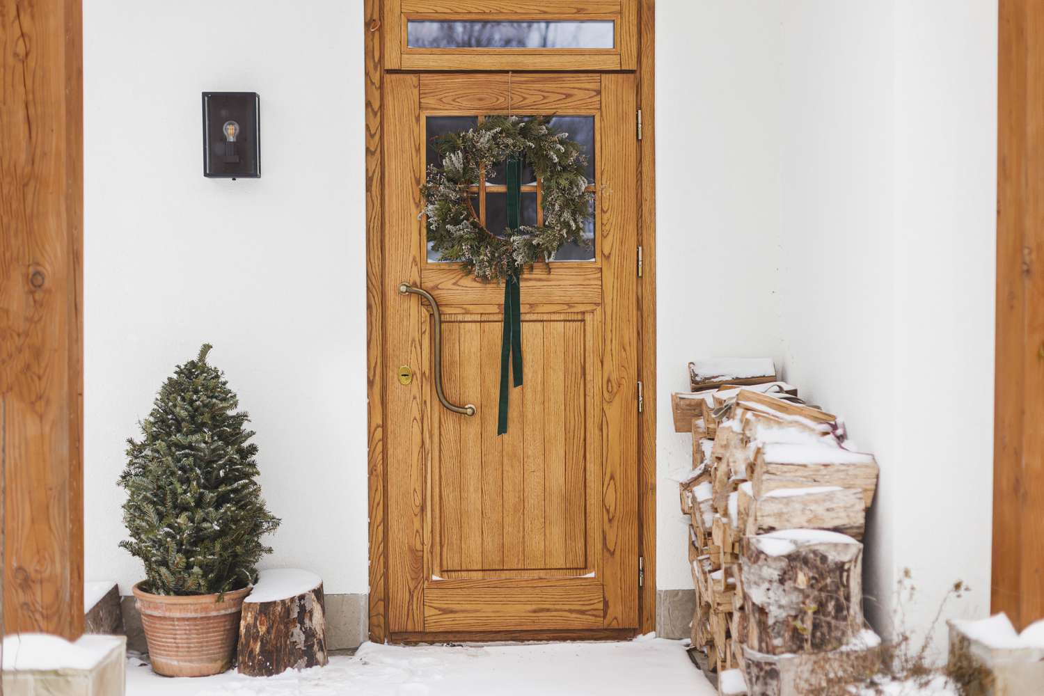 Stylish christmas rustic wreath with ribbon hanging on wooden doors,