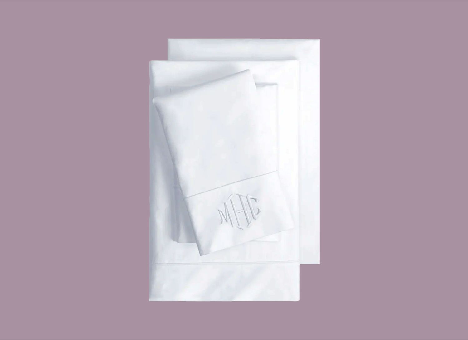 overhead view of stack of monogrammed white sheets