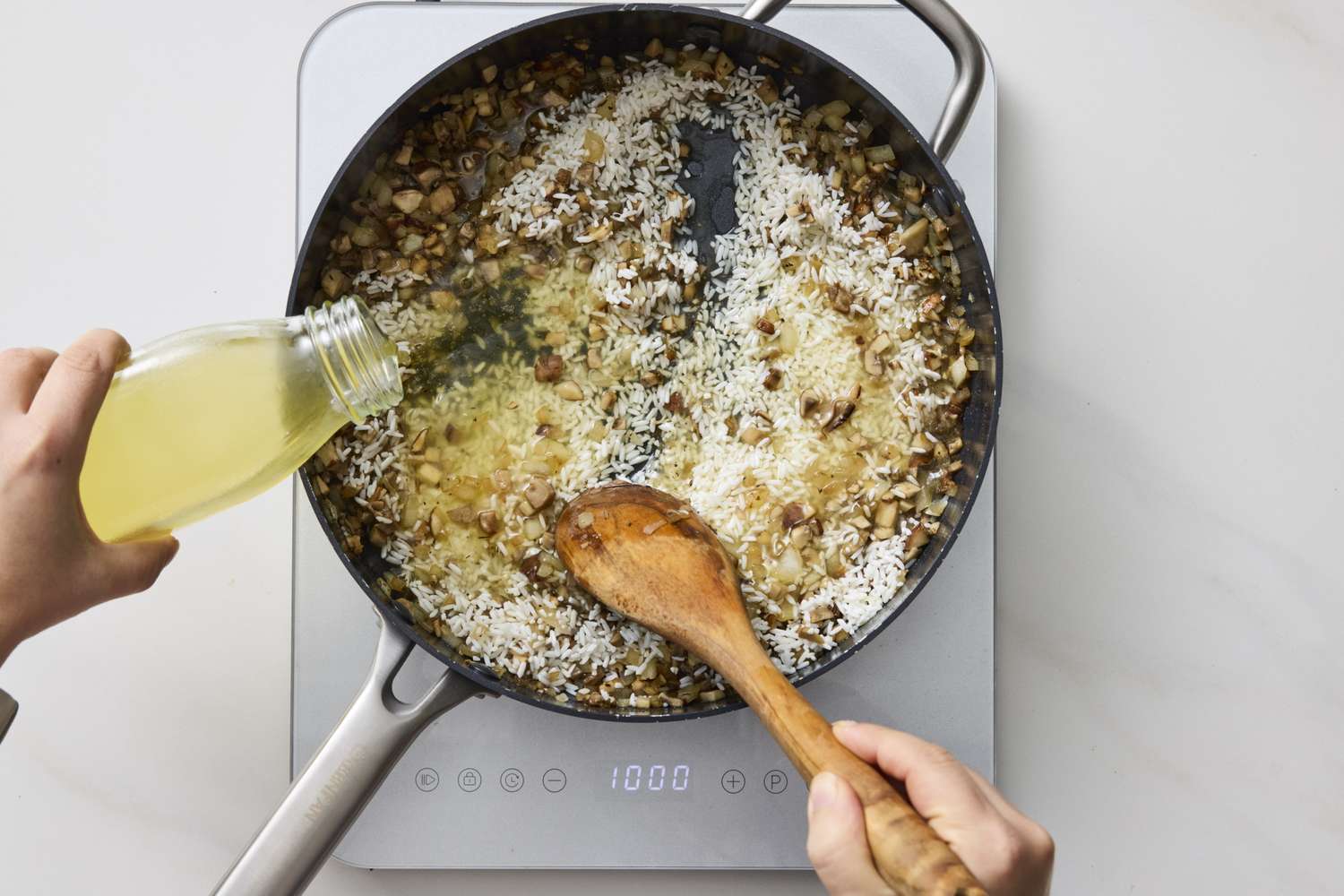 Cooking process showing rice being combined with broth and vegetables in a skillet