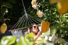 reading a book on a hammock in a garden