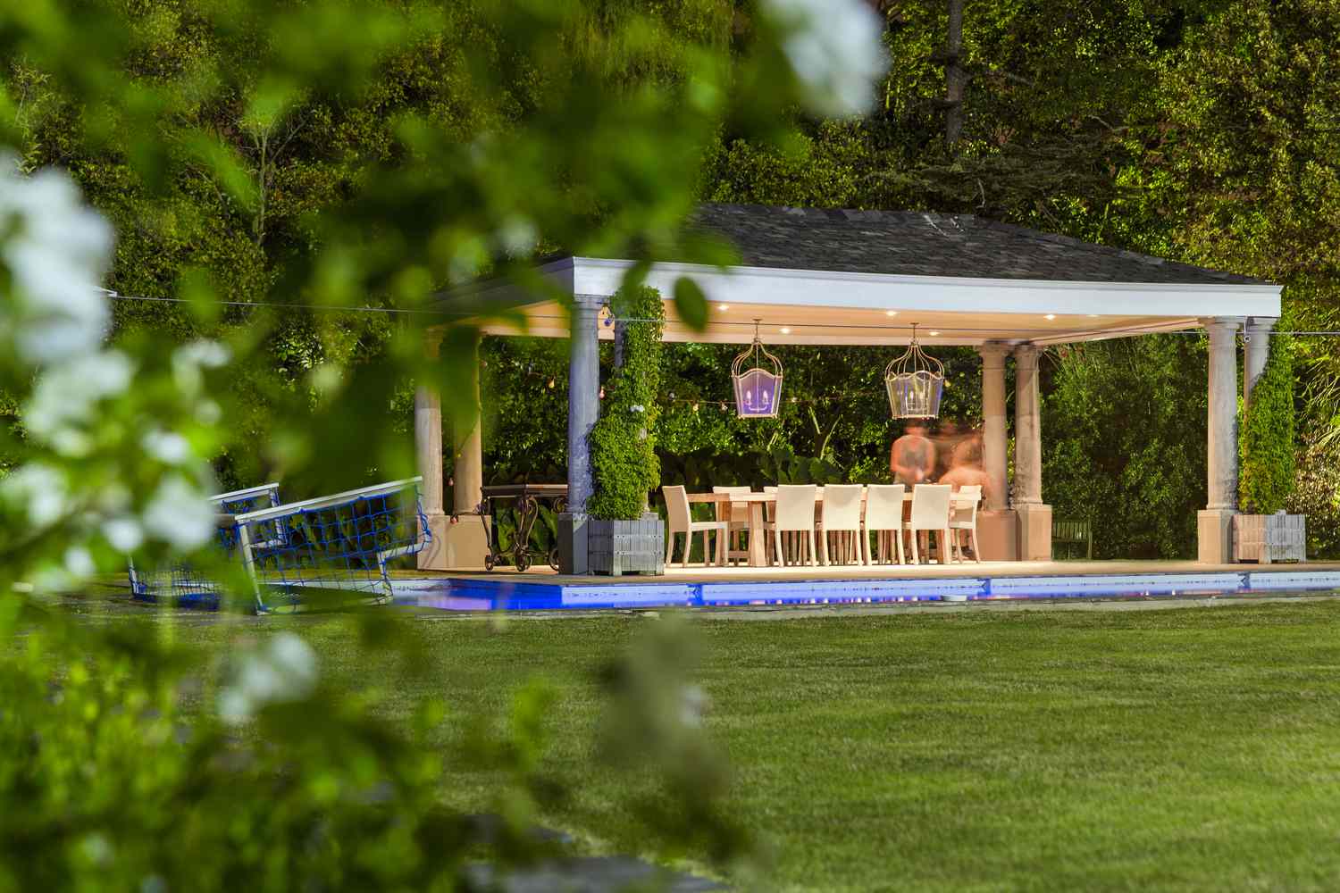 Illuminated gazebo at poolside during night