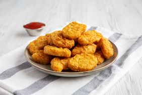 Plate of chicken nuggets with a small cup of ketchup on the side