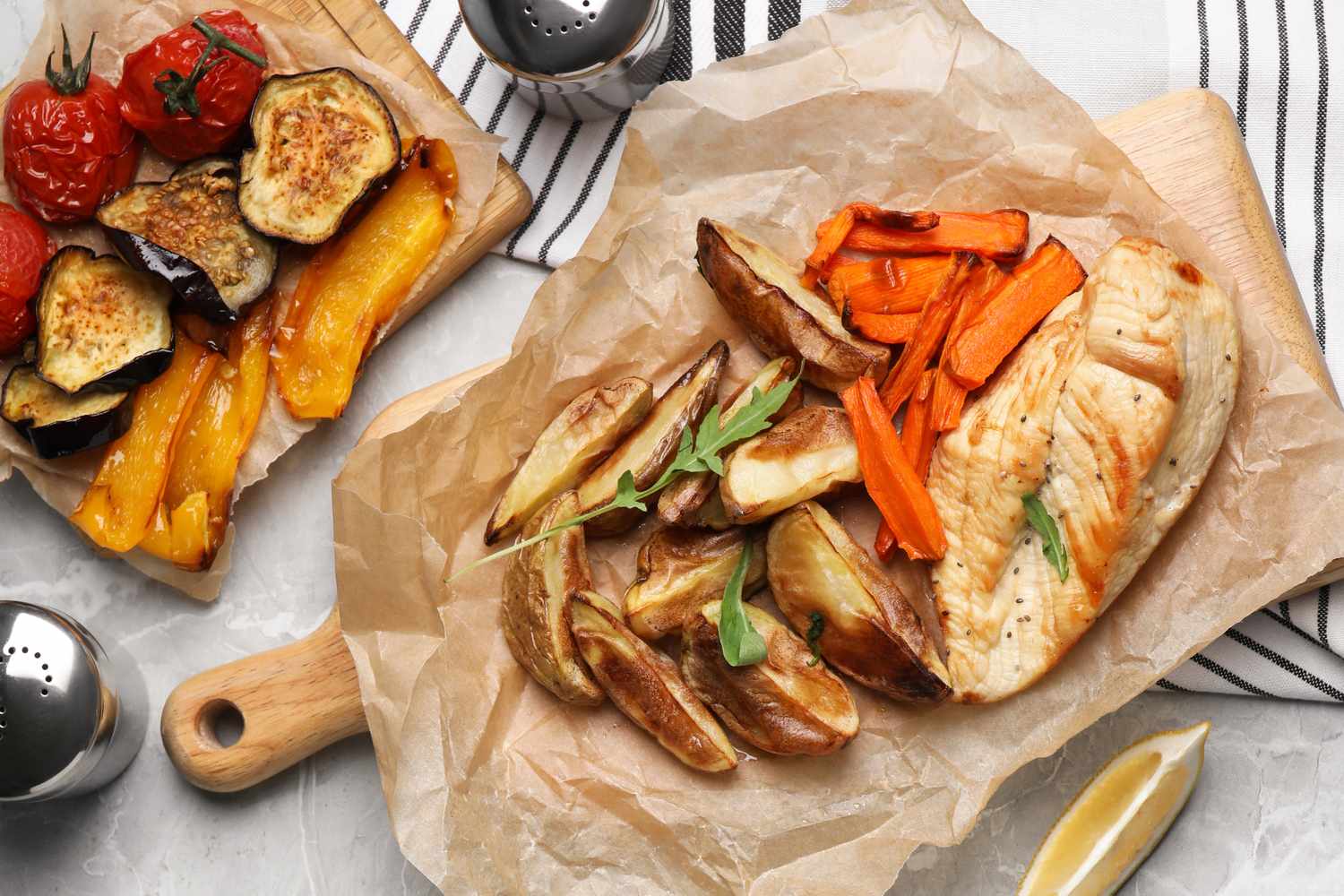Grilled chicken with roasted vegetables and potatoes on parchment served alongside chargrilled eggplant and peppers