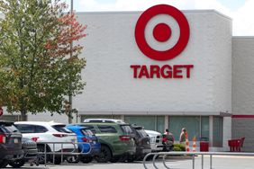 Storefront of Target with parked cars and people entering the building