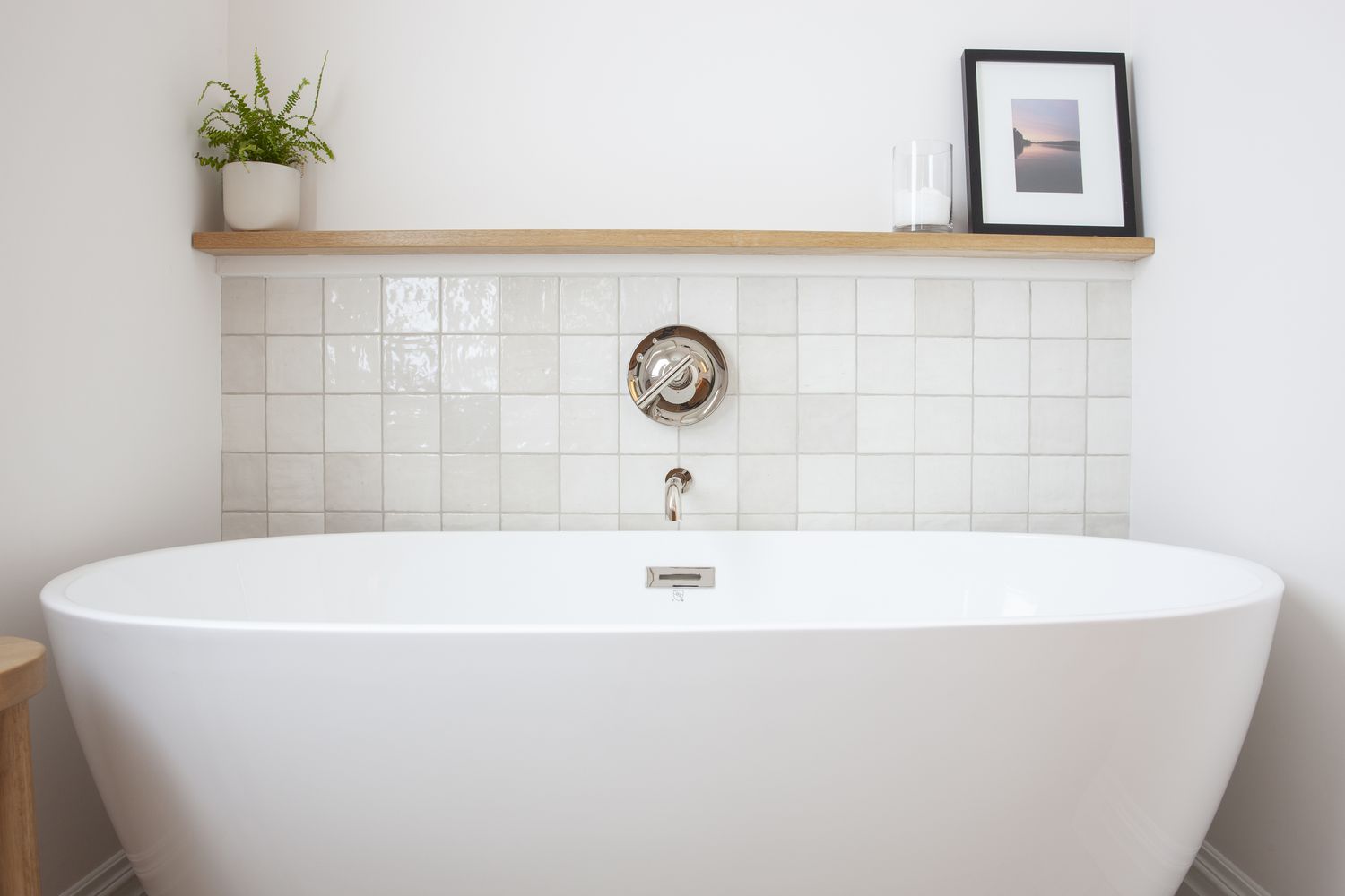 a bathtub with a shelf above