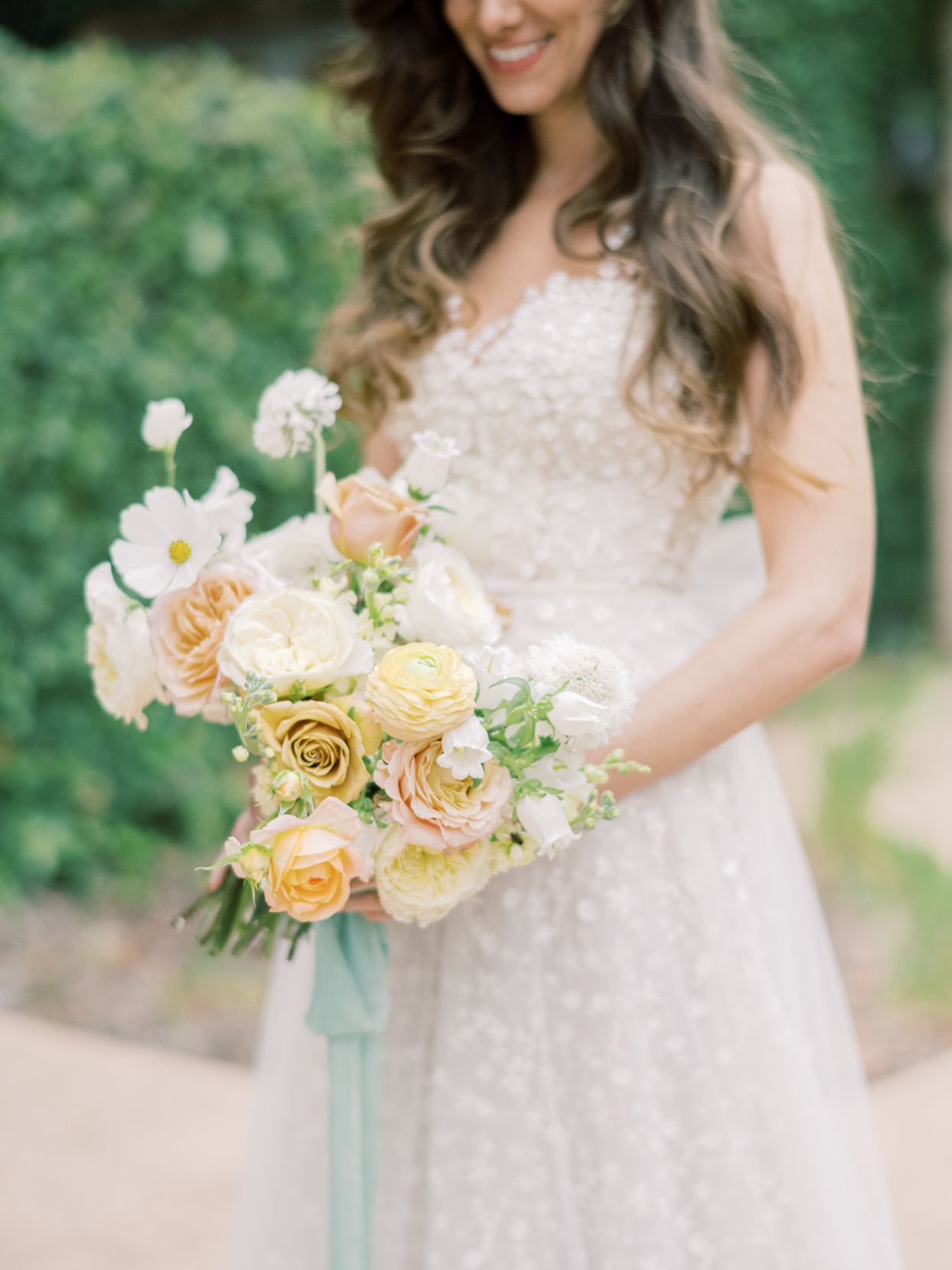 bride holding pastel citrus floral bouquet