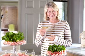martha holding cocktails by table of seafood