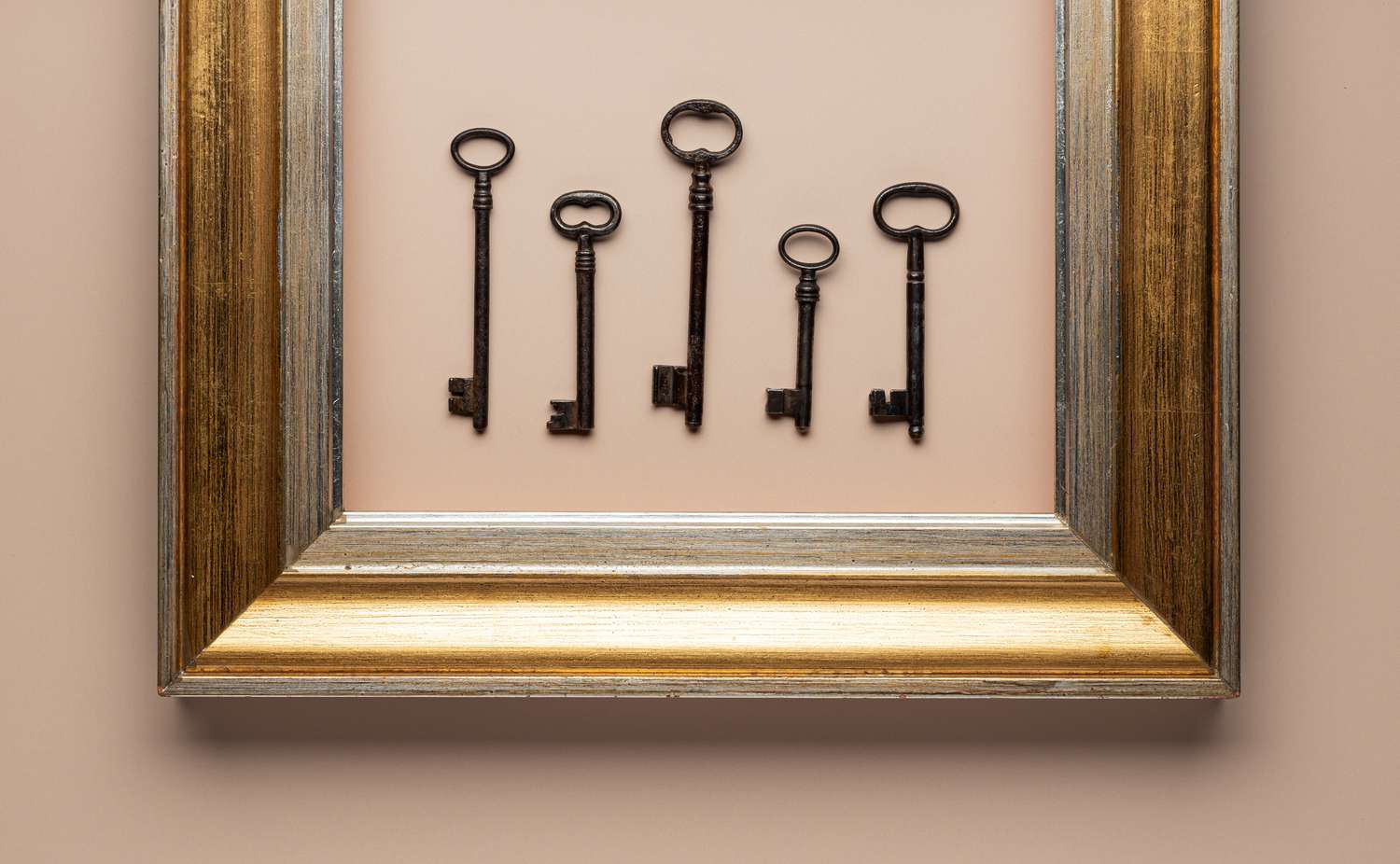Old framed keys against pale rose background
