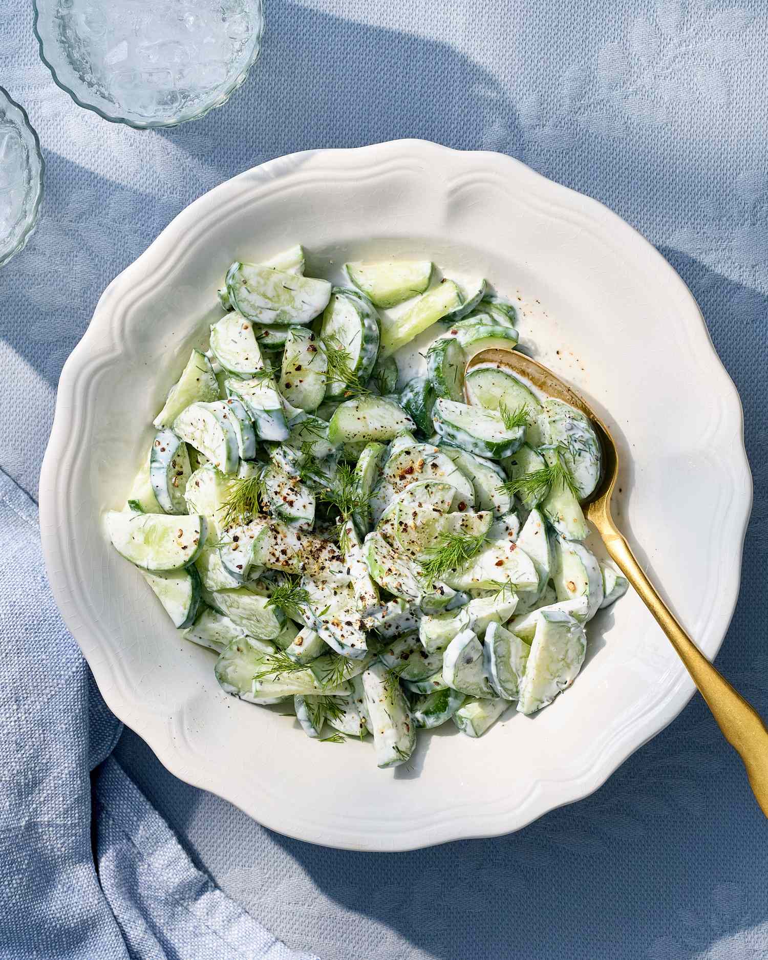 Cucumber salad with sour cream and dill in a white bowl