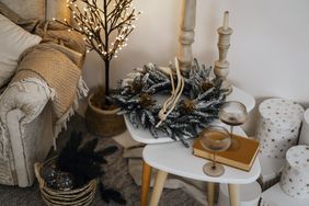 Holiday themed decor with a wreath candles and glasses on a table