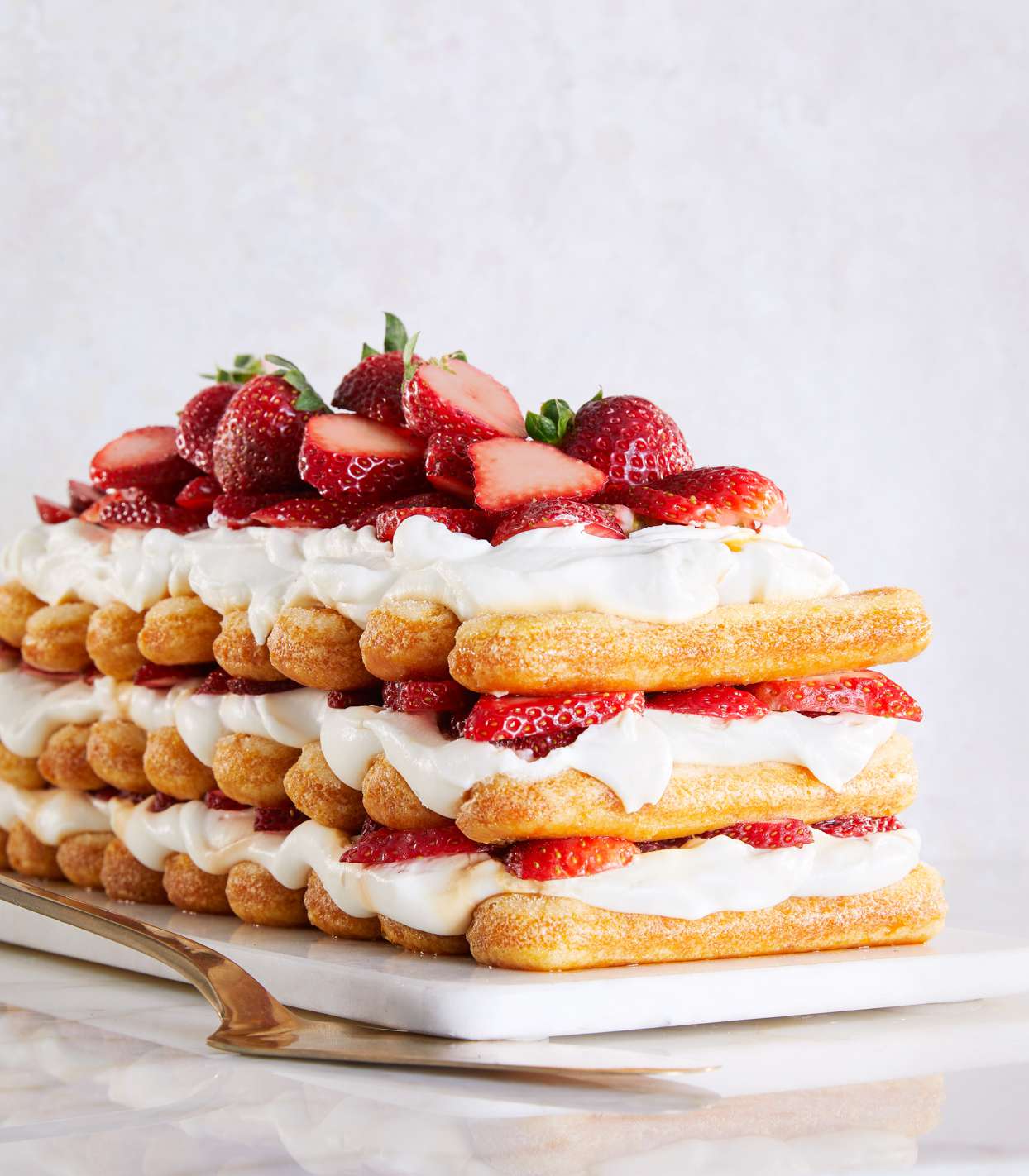 strawberries-and-cream stack cake topped with fresh strawberries