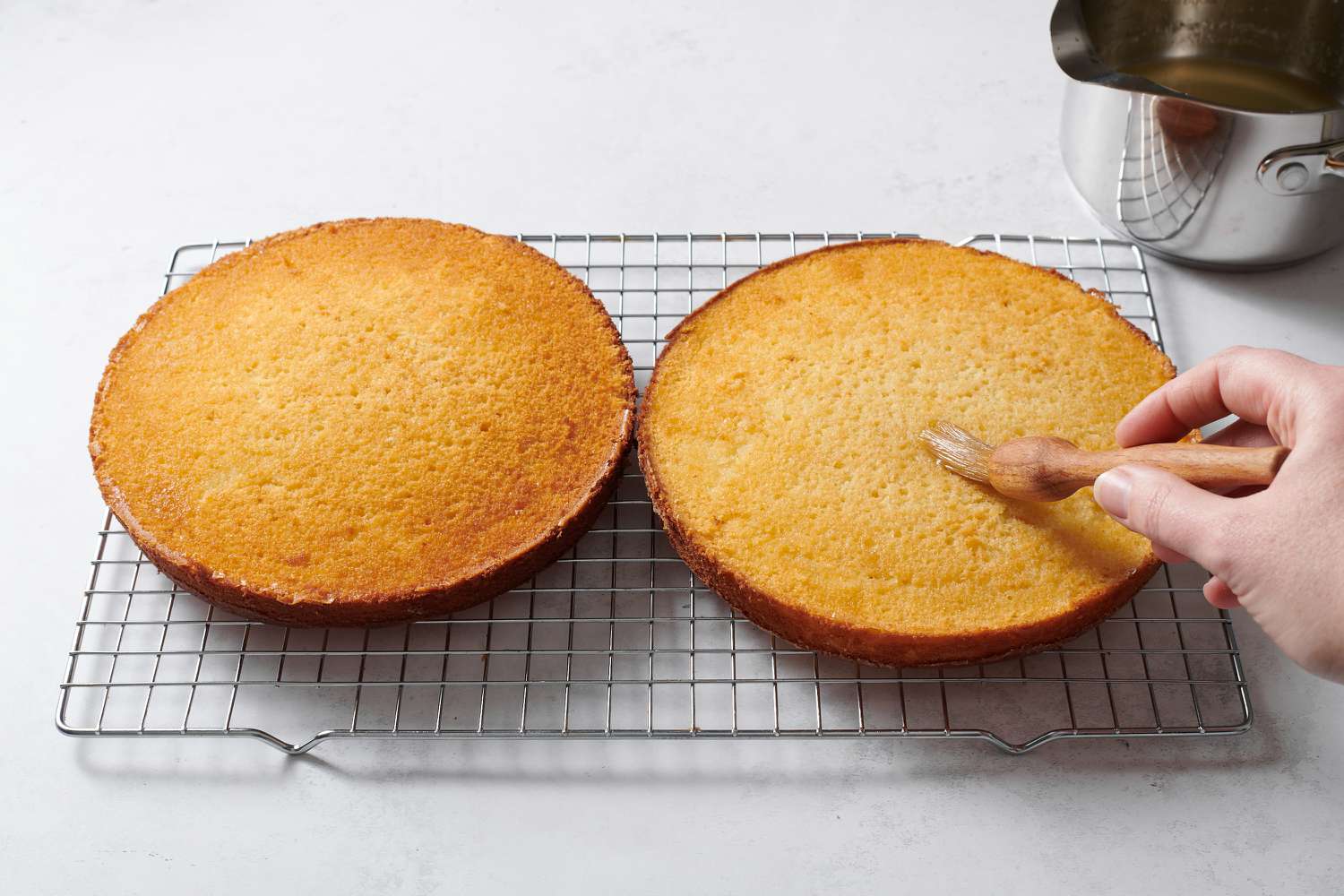 brushing cakes with lemon syrup
