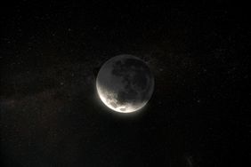 A crescent moon with the dark side faintly visible set against a starry night sky