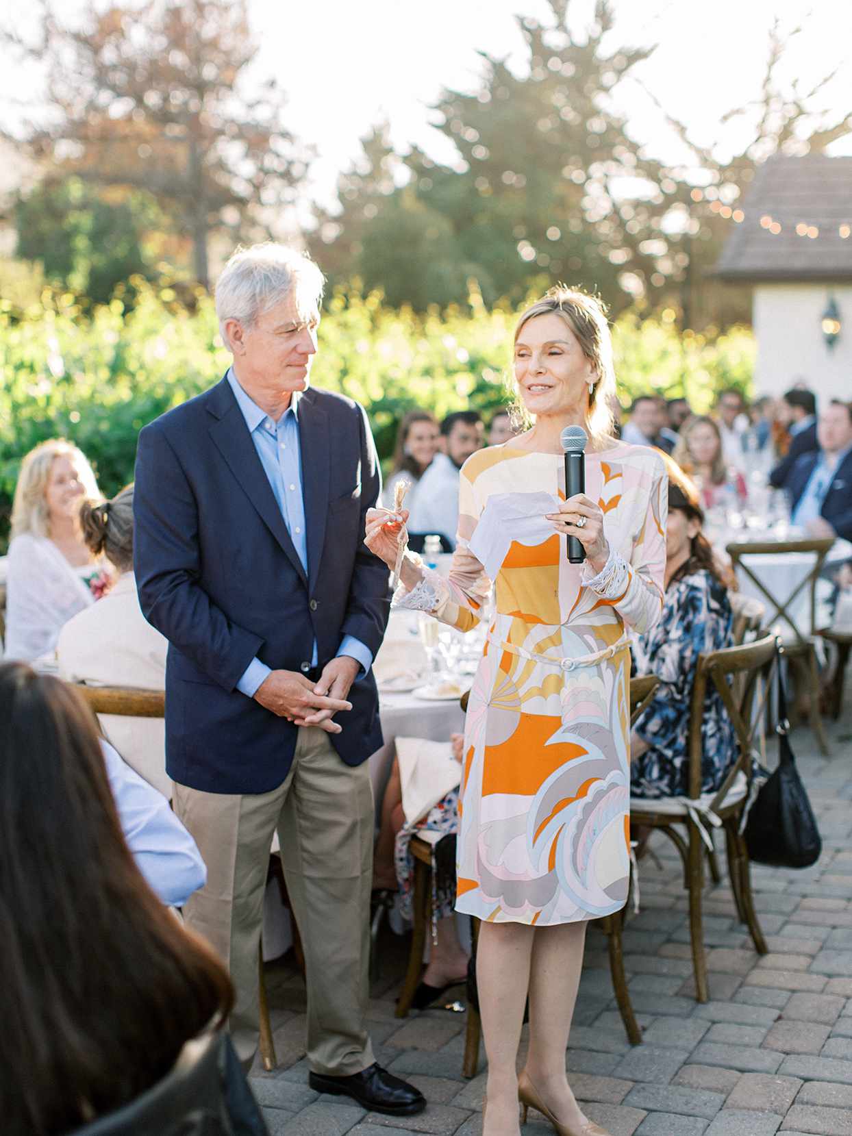 parents giving speech at outdoor rehearsal dinner
