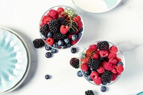 Two bowls of mixed berries including raspberries blackberries and blueberries
