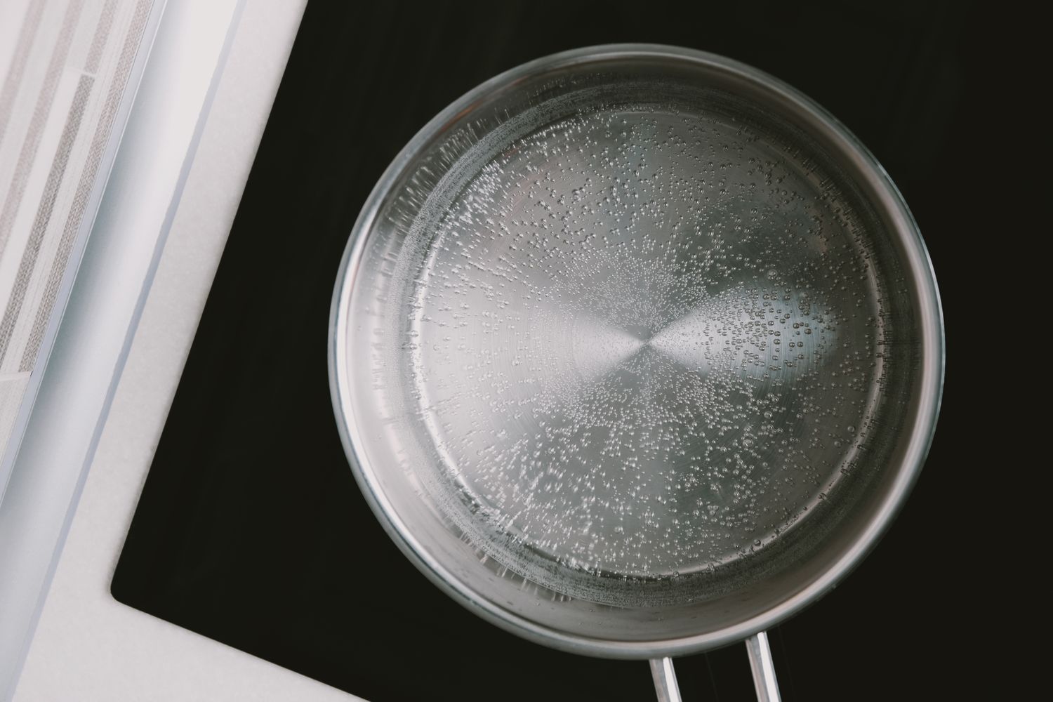 Top view of a pan with water on a modern stovetop