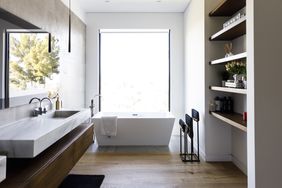 Modern bathroom with a freestanding bathtub floating vanity and open shelving