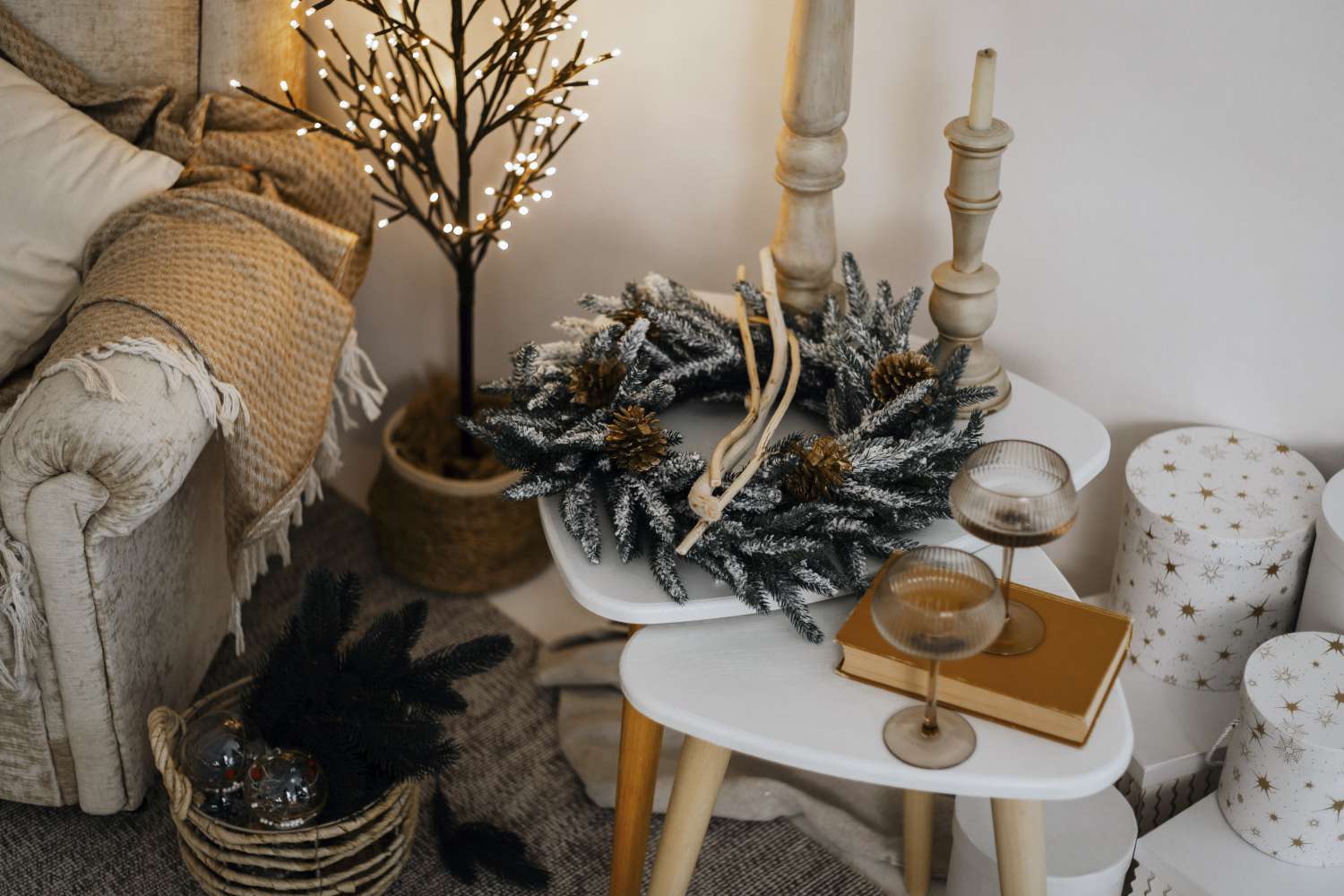 Holiday themed decor with a wreath candles and glasses on a table