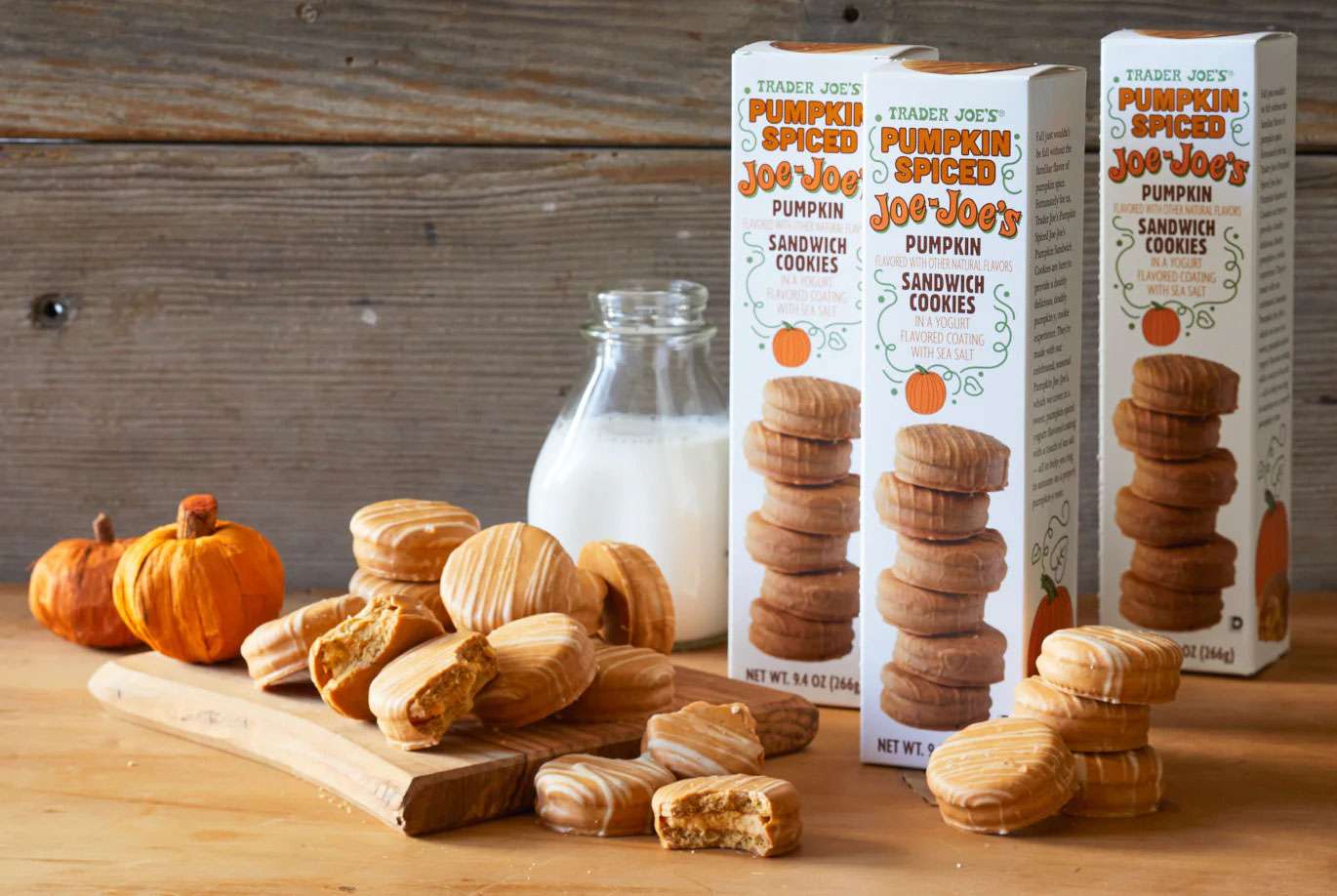 Trader Joes Pumpkin Spice JoeJoes sandwich cookies with pumpkins and a bottle of milk on a wooden surface